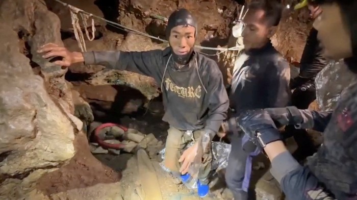 Detik-detik Menegangkan Penyelamatan Penambang Emas di Gua Sempit A rescued man is supported by a volunteer, after seven Lao nationals who had entered a cave to prospect for gold were trapped for more than a week when rising water blocked their exit, in Xaisomboun province, Laos, May 30, 2026, in this screen grab taken from social media video.