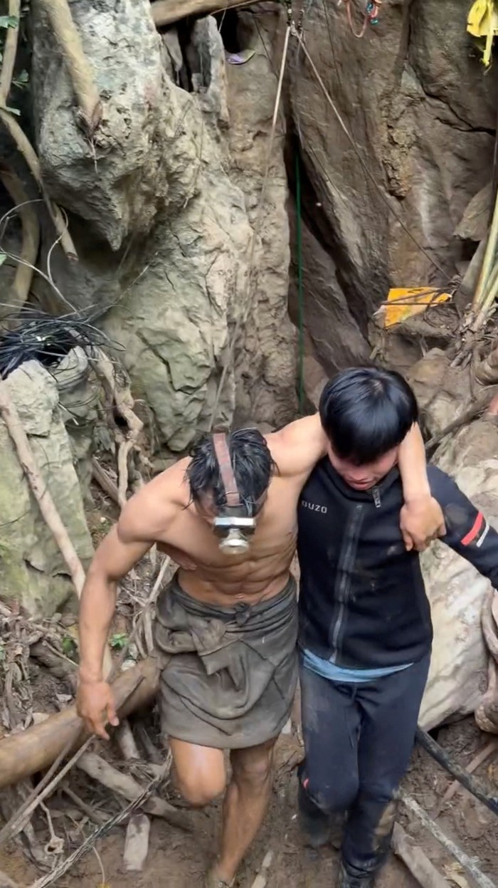 Detik-detik Menegangkan Penyelamatan Penambang Emas di Gua Sempit A rescued man is supported by a volunteer, after seven Lao nationals who had entered a cave to prospect for gold were trapped for more than a week when rising water blocked their exit, in Xaisomboun province, Laos, May 30, 2026, in this screen grab taken from social media video.
