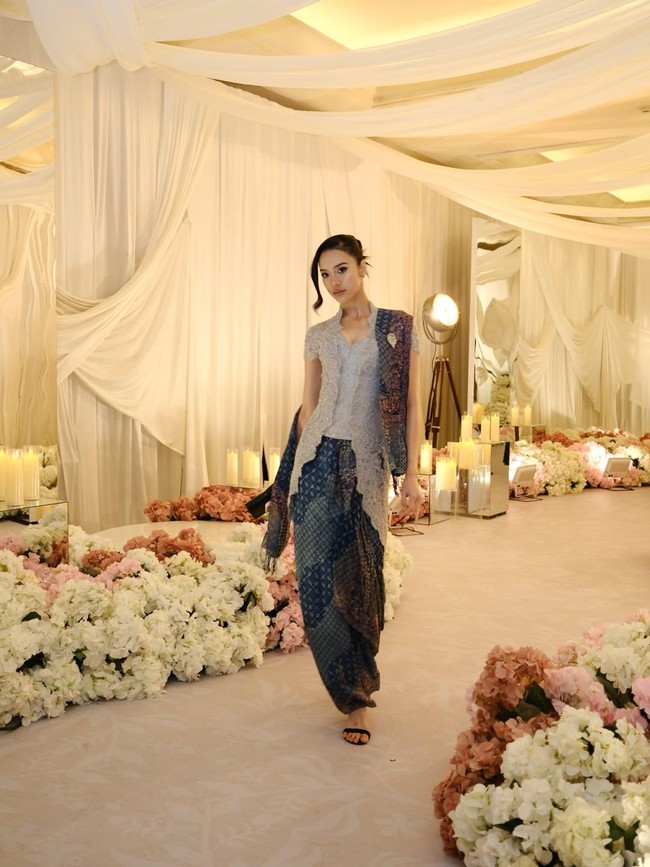 Kain batik warna indigo bergradasi tampak serasi dengan kebaya abu-abu. Selendang batik hadir sebagai pelengkap yang menambah kesan anggun. Foto: Instagram/@anyageraldine