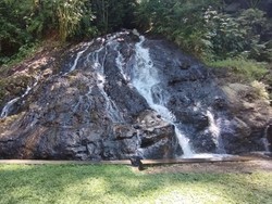 Air mengalir melalui celah bebatuan bak air terjun di Taman Magenda, Gianyar, Bali. Taman Magenda dikenal sebagai sumber air suci dan menjadi tempat pertemuan Rsi Dharma Sadhu dan Ida Ayu Mas Manik Merta Sari.