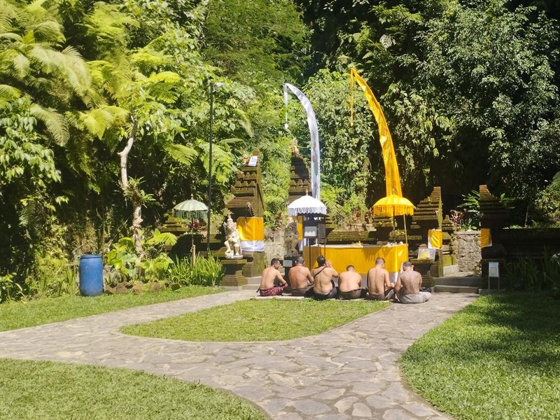 Pengunjung berdoa di Pura Taman Magenda, Gianyar, Bali. Tempat ibadah tersebut berdampingan dengan air terjun dan kolam alami.
