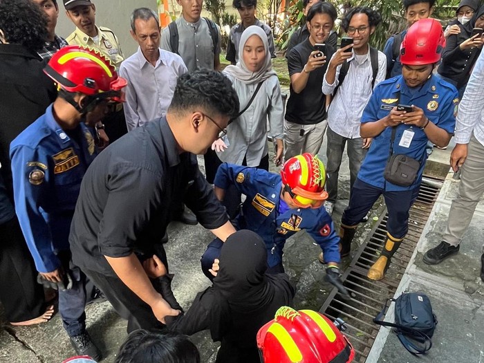 Situasi saat tim Damkar Solo mengevakuasi seorang mahasiswi yang kakinya terperosok ke dalam lubang di Kampus FISIP UNS, Senin (25/5/2026).