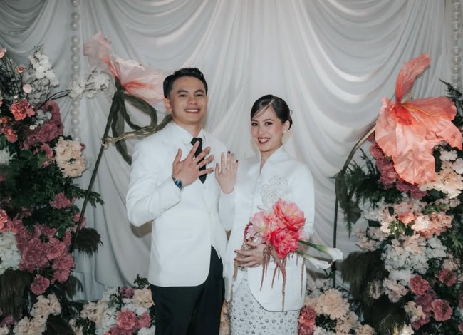 Zara dan Tsaqib tampil simpel dengan dominasi warna putih. Tsaqib mengenakan kemeja putih dipadukan jas senada serta celana panjang dan dasi hitam. Sementara Zara memadukan atasan putih dengan rok panjang bermotif senada. Foto: Instagram/@zaraadhsty