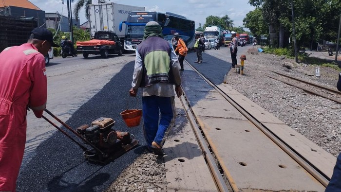 Petugas KAI Daop 8 Surabaya melakukan perawatan jalur rel di perlintasan sebidang JPL 325 Lamongan. Pengguna jalan diimbau mengurangi kecepatan dan mematuhi arahan petugas selama pekerjaan berlangsung.