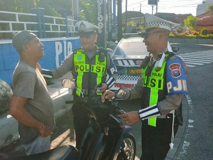 Petugas Unit Jatim V Situbondo Sat PJR Ditlantas Polda Jatim saat memberikan sangsi kepada pelanggar lalulintas di perliman Banyuwangi.