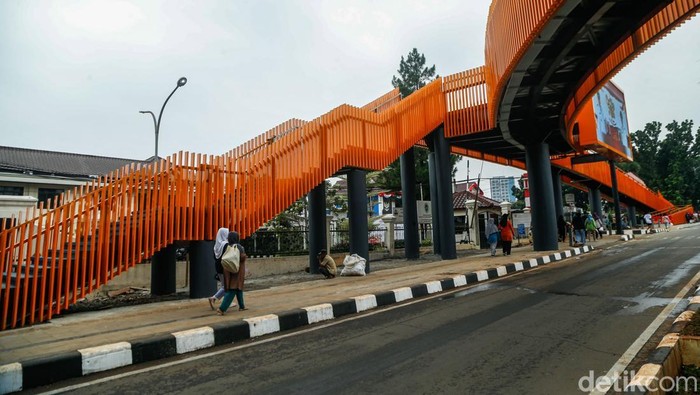Seorang penjual balon melintas di samping Skywalk Tegar Beriman, Cibinong, Kabupaten Bogor, Senin (1/6/2026). Jembatan penyeberangan orang (JPO) tersebut kini menjadi ikon modern terbaru di kawasan tersebut.