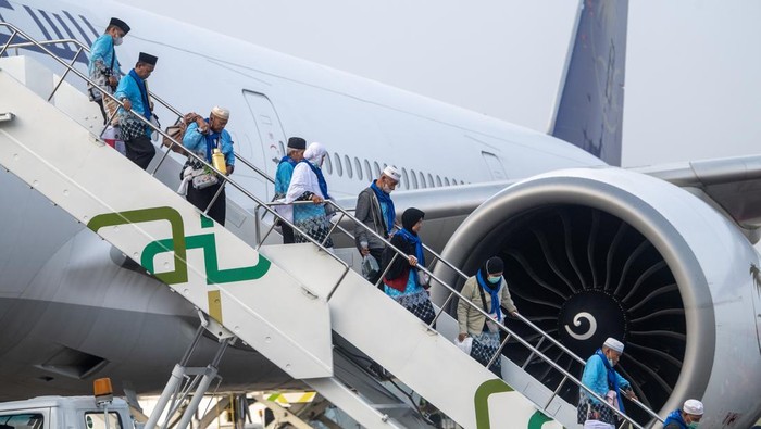 Jamaah haji kelompok terbang (kloter) pertama debarkasi Palembang (PLM 01) berjalan turun dari pesawat Boeing 777-31H(ER) dengan nomor penerbangan SVA5332 milik maskapai penerbangan Saudia setibanya di Bandara Internasional Sultan Mahmud Baddarudin (