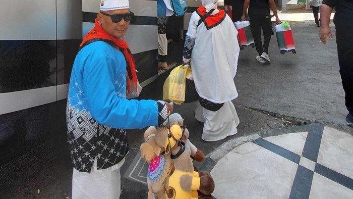 Jemaah haji membawa boneka unta untuk oleh-oleh cucu.