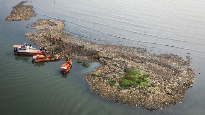 Foto udara petugas mengangkut sampah yang mengendap di perairan laut Jakarta, Rabu (3/6/2026). Petugas Suku Dinas Lingkungan Hidup Kepulauan Seribu dan Unit Penanganan Sampah Badan Air mengerahkan 20 petugas untuk membersihkan endapan sampah di hamparan sedimentasi yang merusak ekosistem laut dan mengganggu aktivitas nelayan. ANTARA FOTO/Sulthony Hasanuddin/nz