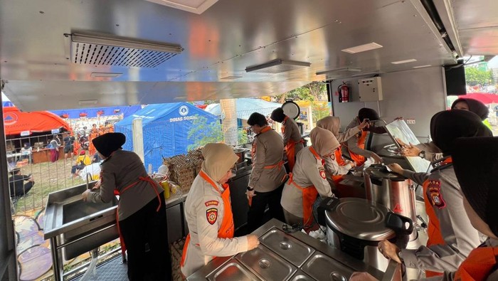 Polwan Polda Metro membagikan makanan siap saji dari dapur lapangan di lokasi kebakaran Kemayoran, Jakarta Pusat, Rabu (3/6/2026).
