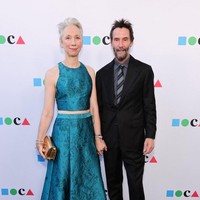 Dalam momen tersebut, Keanu tampil mengenakan setelan jas hitam. Sementara itu, Alexandra atasan warna hijau yang senada dengan roknya. Keduanya tampil mesra dengan saling bergandengan tangan di karpet merah Foto: Getty Images via AFP/EMMA MCINTYRE