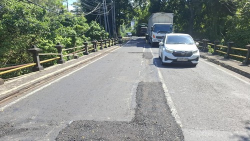 Pihak Balai Jalan menambal sementara lubang di Jembatan Tukad Meluang, Banjar Dinas Soka, Kecamatan Selemadeg, Tabanan sebelum perbaikan dalam skala besar. /