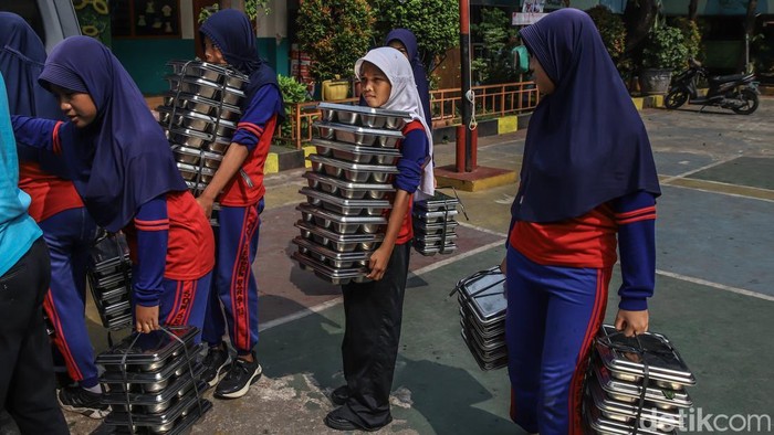 Sejumlah anak membawa makanan bergizi gratis yang baru tiba di salah satu sekolah kawasan Semper Barat, Cilincing, Jakarta Utara, Kamis (4/6/2026). Program Makan Bergizi Gratis (MBG) masih terus berjalan sebagai salah satu program prioritas pemerintah.
