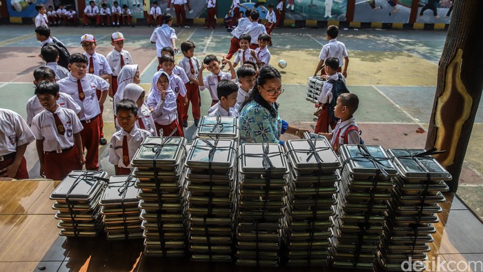 Sejumlah anak membawa makanan bergizi gratis yang baru tiba di salah satu sekolah kawasan Semper Barat, Cilincing, Jakarta Utara, Kamis (4/6/2026). Program Makan Bergizi Gratis (MBG) masih terus berjalan sebagai salah satu program prioritas pemerinta
