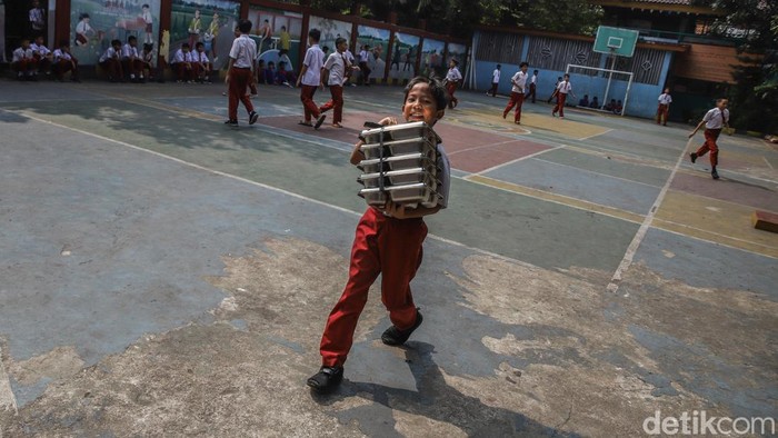 Sejumlah anak membawa makanan bergizi gratis yang baru tiba di salah satu sekolah kawasan Semper Barat, Cilincing, Jakarta Utara, Kamis (4/6/2026). Program Makan Bergizi Gratis (MBG) masih terus berjalan sebagai salah satu program prioritas pemerinta