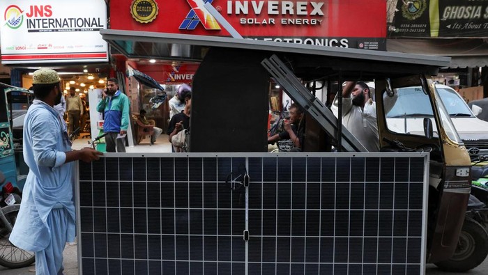 A worker carries a solar panel sheet on his head to load it on a vehicle outside a shop at an electronic items market in Karachi, Pakistan June 3, 2026. REUTERS/Akhtar Soomro