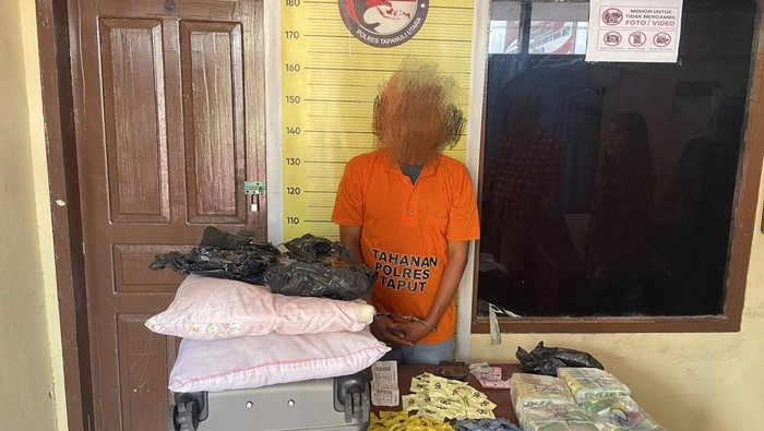 Salah satu tersangka kurir narkoba bersama barang bukti saat ditangkap Polres Taput. (dok. Polres Taput)