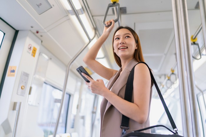 Wanita Naik Transportasi Umum ke Kantor