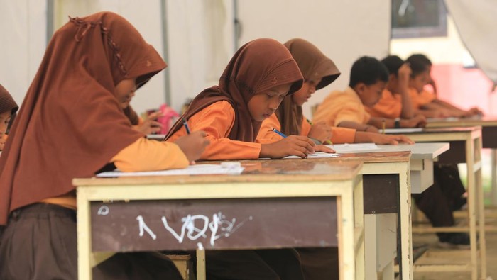 Foto udara sejumlah siswa Sekolah Dasar Negeri (SDN) Alue Lhok mengikuti ujian di tenda darurat, di Desa Jambak, Kecamatan Pante Ceureumen, Aceh Barat, Aceh, Jumat (5/6/2026). Pihak sekolah mengunakan tenda darurat sebagai tempat belajar mengajar karena keterbatasan ruang kelas dan fasilitas sekolah yang rusak akibat bencana hidrometeorologi akhir November 2025. ANTARA FOTO/Syifa Yulinnas/kye