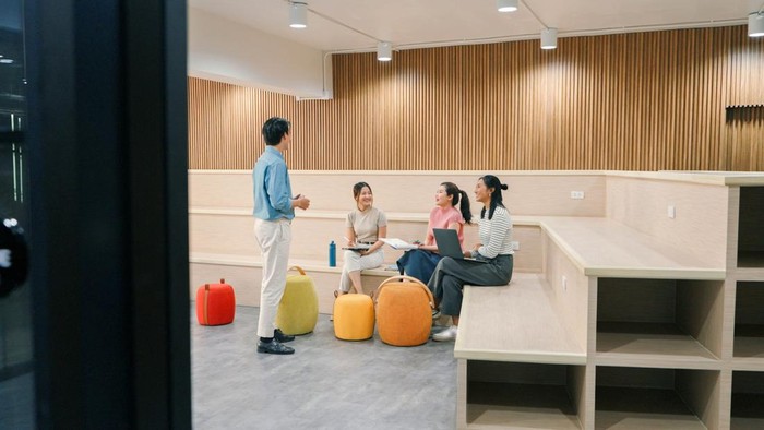 Team brainstorming session in a contemporary office, showcasing casual collaboration, creativity, and productivity among young multicultural professionals.