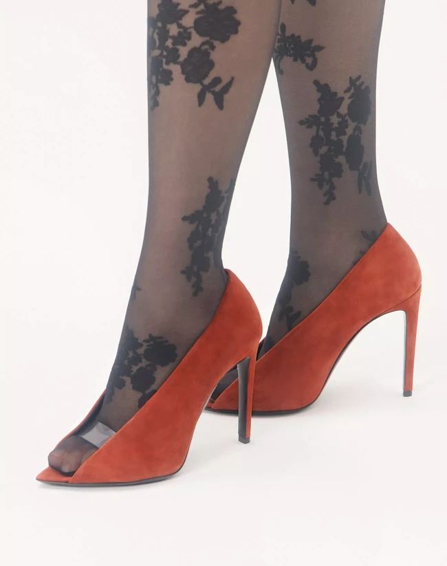 Sepatu terbaru Valentino Garavani, Open Toe Revele Suede Pumps, memiliki desain open toe yang memperlihatkan jari kaki. Terdapat strap transparan berbahan polimer yang melintang di bagian depan sepatu, menciptakan efek seolah jari kaki ‘mengintip’ keluar. Siluetnya yang tidak biasa membuat banyak pengguna internet melontarkan komentar satir, hingga menyamakannya dengan kuku babi. Foto: Dok. Valentino Garavani
