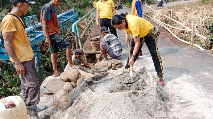 Personel Polsek Jayaloka bersama warga memperbaiki jembatan rusak di Desa Purwodadi, Jayaloka, Musi Rawas, Sumatera Selatan (Sumsel).