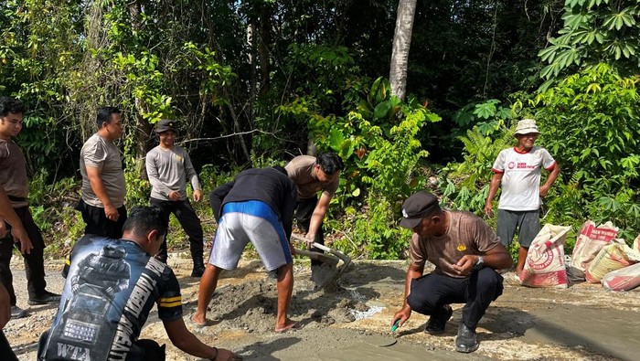 Polisi bersama masyarakat bergotong royong perbaiki jalan rusak dan berlubang.