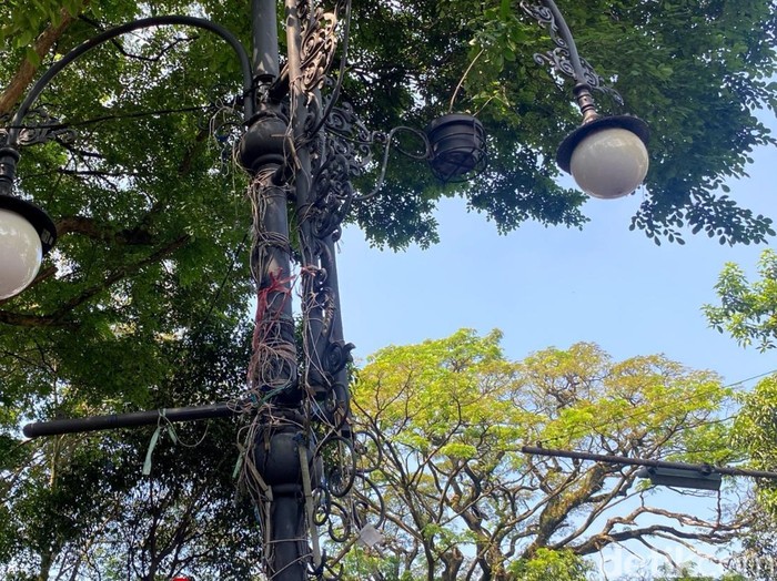 Tiang lampu di Bandung dipenuhi tali bekas spanduk.