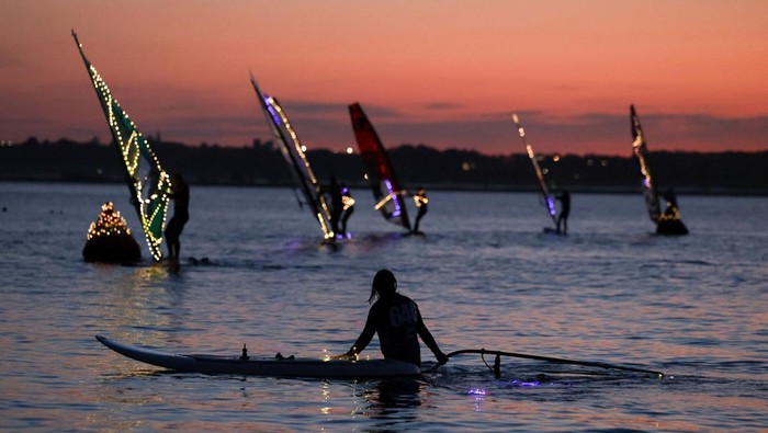 Suasana malam di Rewa, Polandia, berubah menjadi panggung spektakuler saat festival “Garnier King of the Bay” menghadirkan pertunjukan olahraga air yang digelar di tengah gelapnya malam, Jumat (6/6/2026). Lampu-lampu yang dipasang pada peralatan para peserta menciptakan pemandangan visual yang memukau di atas permukaan laut. REUTERS/Kacper Pempel