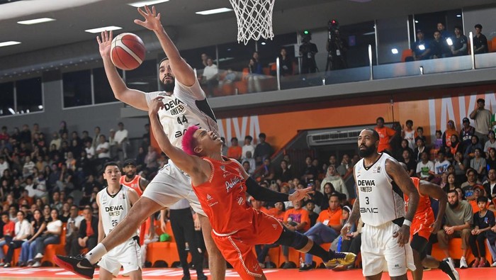 Pebasket Dewa United Banten Joshua Bryan Ibarra (kiri) memblok bola dari pebasket Pelita Jaya Basketball Jakarta  Andakara Prastawa Dhyaksa (kanan) dalam pertandingan pertama seri Best of Five pada Semifinal Indonesian Basketball League (IBL) 2026 di