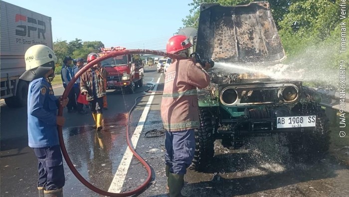 Petugas Damkar Kabupaten Cirebon saat mencoba memadamkan mobil yang terbakar