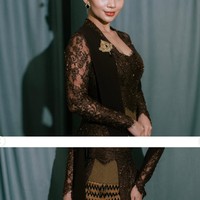 Permukaan kebaya dihiasi payet dan bordir bernuansa senada yang memberikan efek berkilau lembut. Bagian lengan dibuat dari material transparan dengan detail renda dan bordir. Foto: Instagram/@arieltatum
