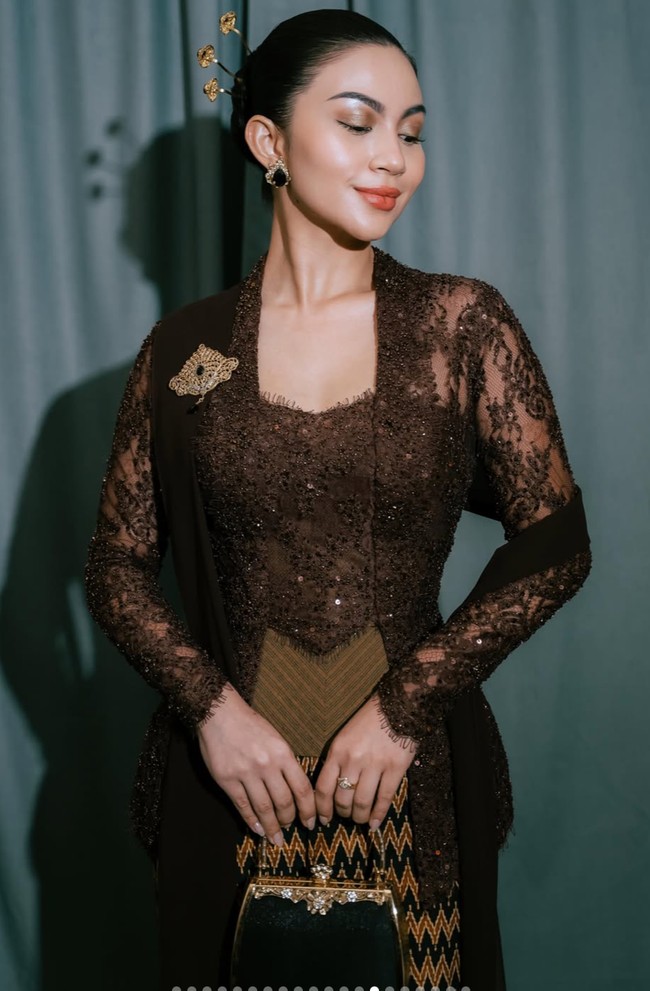 Penampilannya semakin istimewa dengan penggunaan cincin dan tas hitam milik sang nenek. Tas mungil bergaya vintage dengan detail emas tersebut menjadi pelengkap penampilannya. Foto: Instagram/@arieltatum
