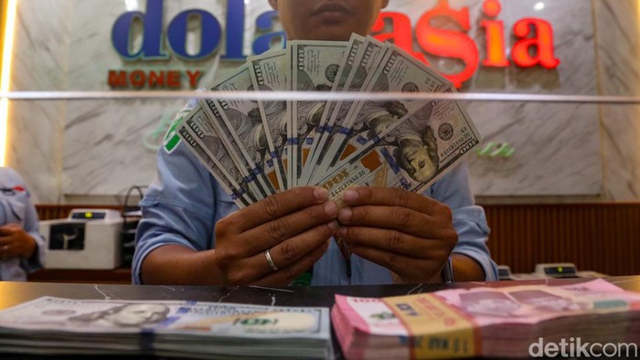 Petugas menata mata uang Dolar AS dan Rupiah di penukaran valuta asing di Dolarasia, Jakarta, Senin (8/6/2026). Berdasarkan data Bloomberg, dolar AS kini berada pada level Rp 18.201 atau menguat 0,91%. Mata uang itu merangkak naik dari level Rp 18.10