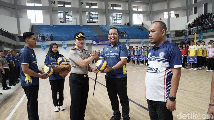 Kapolres Bojonegoro AKBP Afrian Satya Permadi menyerahkan bola voli ke perwakilan PBVSI  Bojonegoro