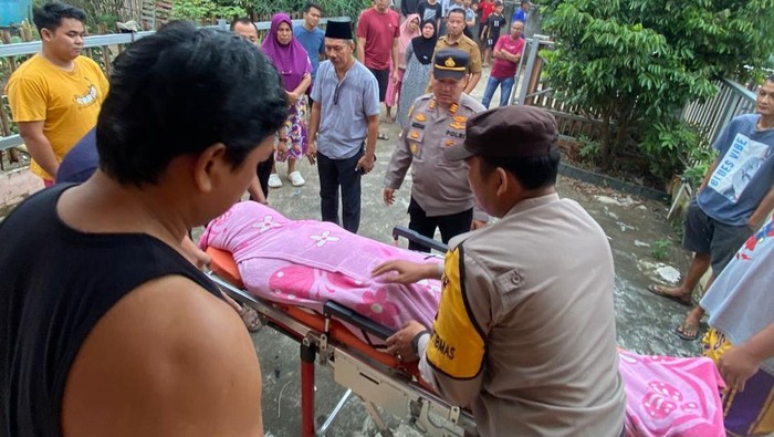 Polisi dan warga mengevakuasi jasad korban.