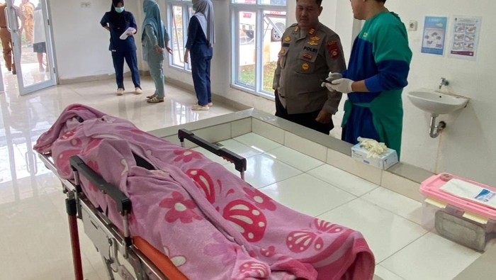 Polisi saat membawa jasad korban ke rumah sakit
