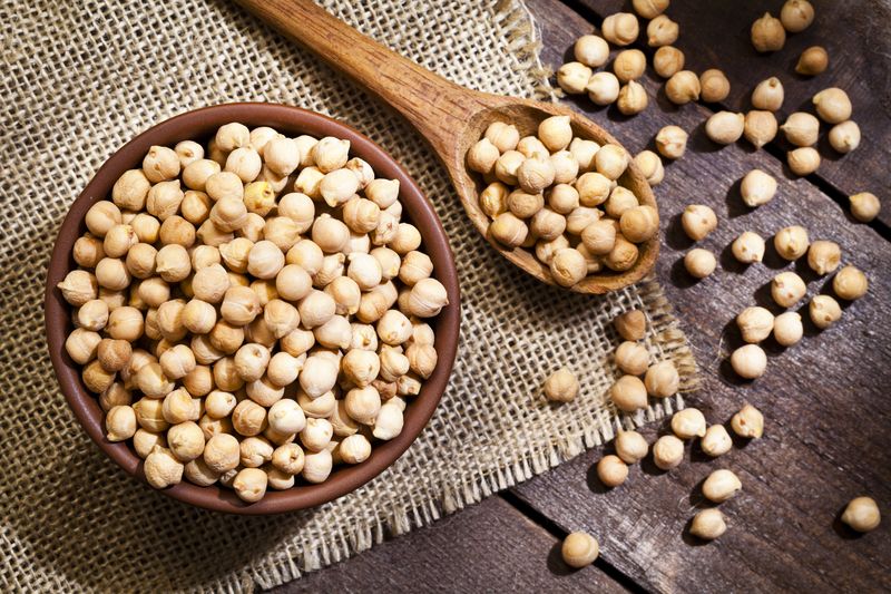 Kacang Arab Top view of a brown bowl filled with chickpeas shot on rustic wood table. A wooden spoon is beside the bowl with some lentils on it. DSRL studio photo taken with Canon EOS 5D Mk II and Canon EF 100mm f/2.8L Macro IS USM