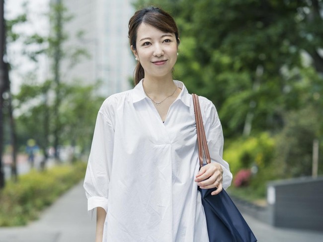 Asian young housewife in white shirt going out with shopping bag