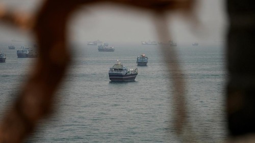 Aktivitas maritim di Selat Hormuz kembali menjadi perhatian dunia setelah deretan kapal terlihat berlabuh dan melintasi salah satu jalur pelayaran paling strategis di dunia tersebut. Pemandangan aktivitas kapal yang terlihat dari wilayah Musandam, Oman, Kamis (11/6/2026), menggambarkan pentingnya perairan ini sebagai urat nadi perdagangan energi global. REUTERS/Stringer