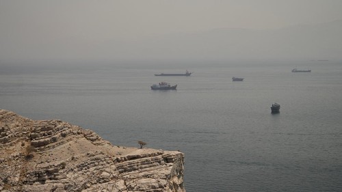 Aktivitas maritim di Selat Hormuz kembali menjadi perhatian dunia setelah deretan kapal terlihat berlabuh dan melintasi salah satu jalur pelayaran paling strategis di dunia tersebut. Pemandangan aktivitas kapal yang terlihat dari wilayah Musandam, Oman, Kamis (11/6/2026), menggambarkan pentingnya perairan ini sebagai urat nadi perdagangan energi global. REUTERS/Stringer