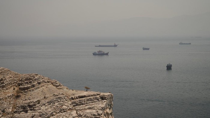 Aktivitas maritim di Selat Hormuz kembali menjadi perhatian dunia setelah deretan kapal terlihat berlabuh dan melintasi salah satu jalur pelayaran paling strategis di dunia tersebut. Pemandangan aktivitas kapal yang terlihat dari wilayah Musandam, Oman, Kamis (11/6/2026), menggambarkan pentingnya perairan ini sebagai urat nadi perdagangan energi global. REUTERS/Stringer