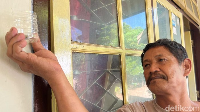 Nono menunjukkan kaleng jimpitan di salah satu rumah warga