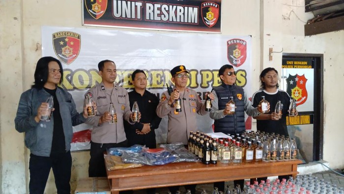 Polisi menunjukkan barang bukti miras yang disita dari penjual miras online di Tol Pasuruan.