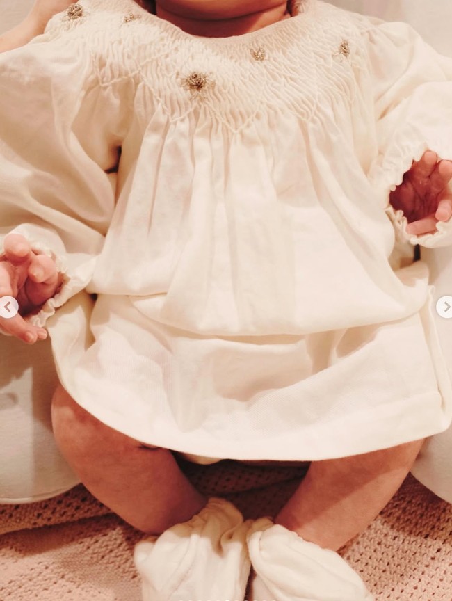 Baby Soleil tampil dengan dress putih. Dress tersebut dihiasi bentuk seperti bunga-bunga kecil 3D warna emas. Foto: Instagram/@alyssadaguise