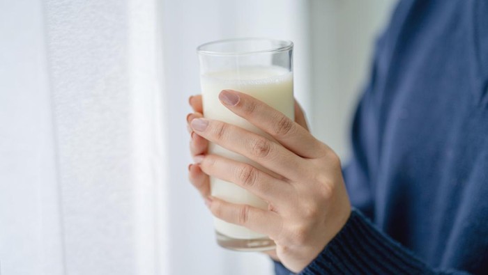 Woman holding a glass of milk.