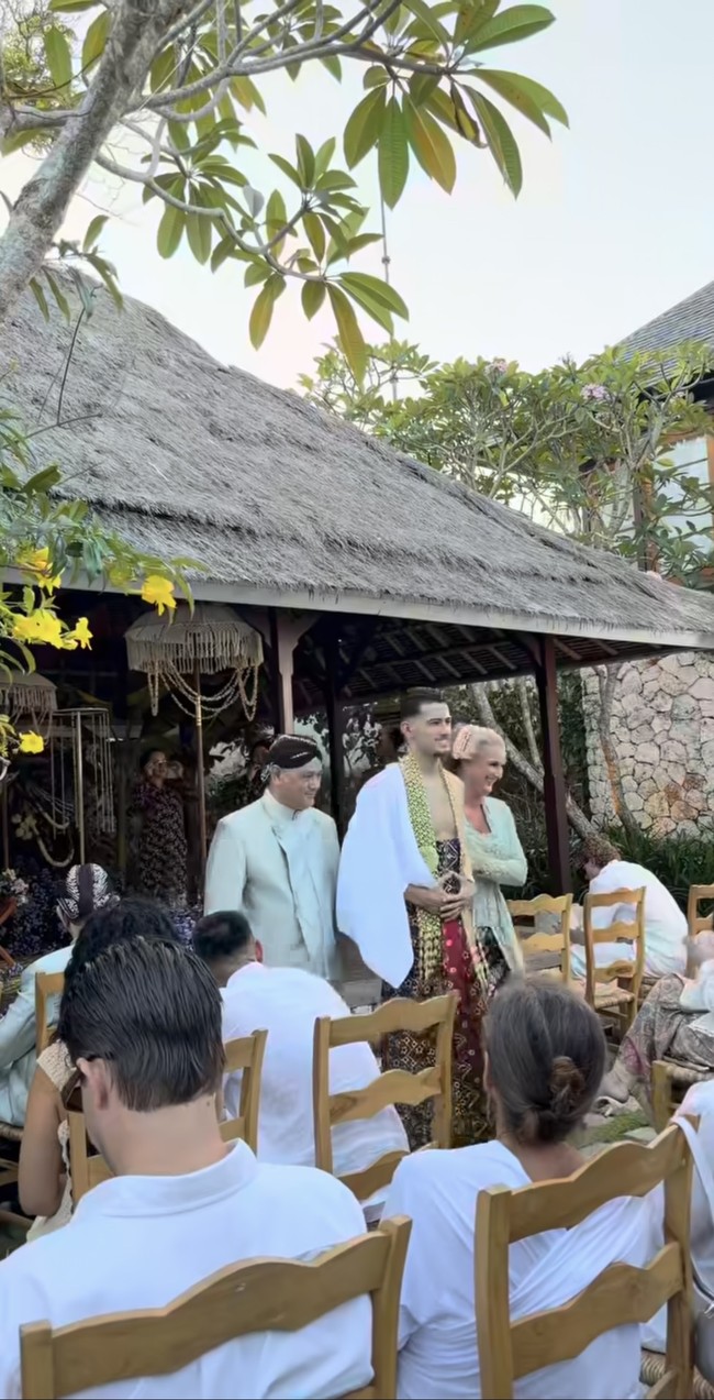 Hubner berjalan didampingi orangtuanya setelah prosesi siraman. Terlihat ia mengenakan kain yang didominasi warna hitam dan merah serta ronce melati. Foto: Instagram/@sitimodiste.kebaya