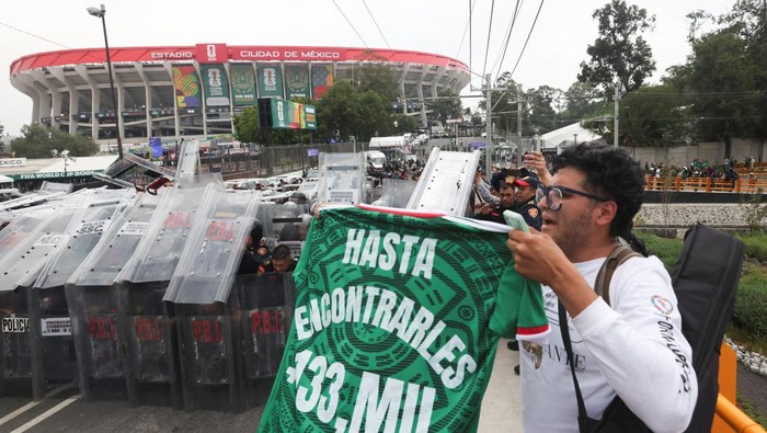 Police officers stand guard and shield themselves during a protest on the day of the opening match of the 2026 FIFA World Cup, outside the Azteca Stadium, in Mexico City, Mexico, June 11, 2026. REUTERS/Fred Ramos