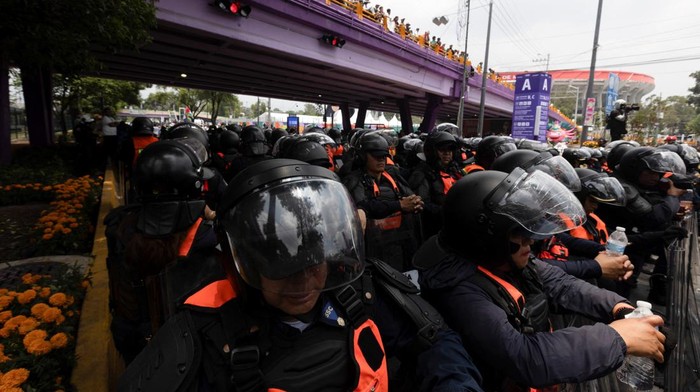 Police officers stand guard and shield themselves during a protest on the day of the opening match of the 2026 FIFA World Cup, outside the Azteca Stadium, in Mexico City, Mexico, June 11, 2026. REUTERS/Fred Ramos