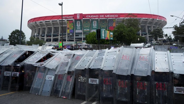 Police officers stand guard and shield themselves during a protest on the day of the opening match of the 2026 FIFA World Cup, outside the Azteca Stadium, in Mexico City, Mexico, June 11, 2026. REUTERS/Fred Ramos